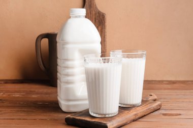 Tahta masada bir şişe ve bir bardak süt.