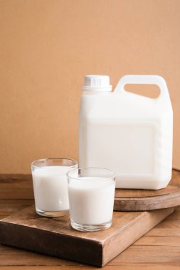 Tahta masada bir şişe ve bir bardak süt.