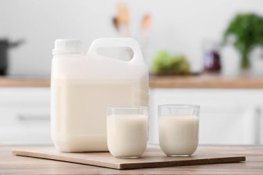 Mutfaktaki masada galon şişe ve bir bardak süt.
