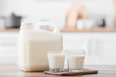 Mutfaktaki masada galon şişe ve bir bardak süt.
