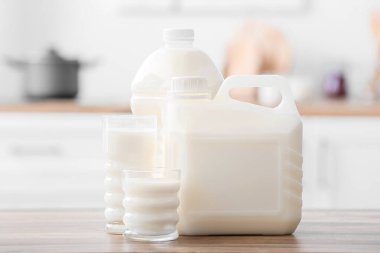 Mutfaktaki masada galon şişe ve bardak süt var.