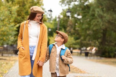 Küçük oğlunu okula götüren kadın.