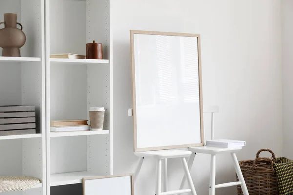 Blank poster on chairs near light wall in room