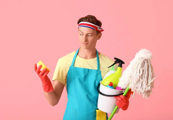 ピンクの背景に掃除用品を持つハンサムな男 — ストック写真