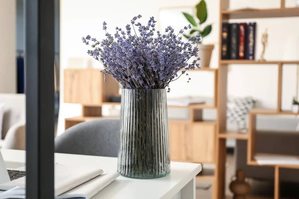 Masanın üzerinde güzel lavanta çiçekleri olan vazo.