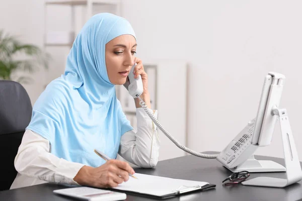 在办公室工作时 穆斯林秘书通过电话交谈 — 图库照片