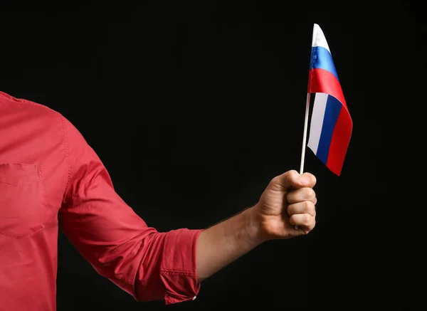 暗い背景にロシアの旗を持つ男性の手 — ストック写真