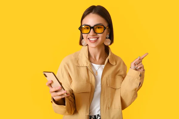 Mooie Jonge Vrouw Stijlvolle Kleding Met Telefoon Wijzen Naar Iets — Stockfoto