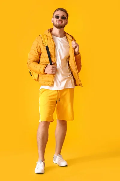 穿着黄色背景夹克的时髦年轻人 — 图库照片