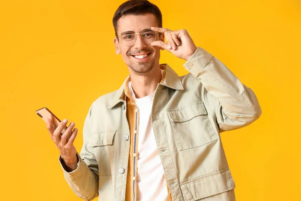 Hombre Joven Chaqueta Elegante Con Teléfono Móvil Sobre Fondo Amarillo — Foto de Stock