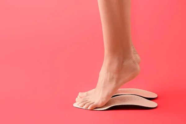 Weibliche Füße Und Orthopädische Einlagen Auf Rotem Hintergrund — Stockfoto
