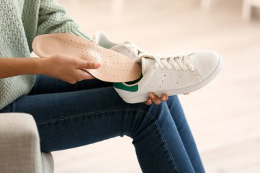 Kadın ayakkabısına ortopedik taban takıyor.