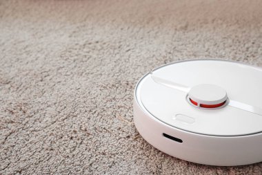 Modern robot süpürgesi yumuşak halıda.