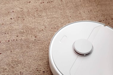 Modern robot süpürgesi yumuşak halıda.