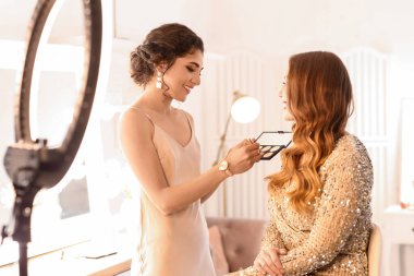 Makyaj sanatçısı güzellik salonunda güzel bir modelle çalışıyor.