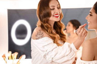 Makyaj sanatçısı güzellik salonunda güzel bir modelle çalışıyor.