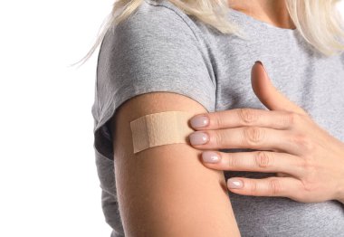 Beyaz arka planda uygulamalı nikotin bandı olan olgun bir kadın, yakın plan. Sigara içmeyi bırakma