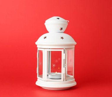 Kırmızı arka planda yanan mum ile güzel bir Noel feneri