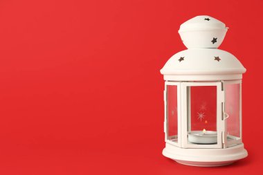 Kırmızı arka planda yanan mum ile güzel bir Noel feneri