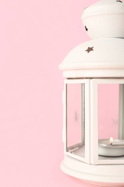 Pembe arka planda yanan mumu olan güzel Noel feneri, yakın plan.