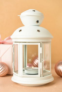 Bej arka planda yanan mum ve topları olan güzel Noel feneri