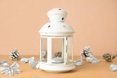 Bej arka planda yanan mum ve dekorla güzel bir Noel feneri.