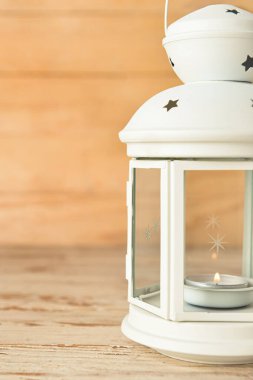 Ahşap zemin üzerinde yanan mum olan güzel Noel feneri, yakın plan.