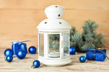 Ahşap zemin üzerinde yanan mum ve dekorla güzel bir Noel feneri.