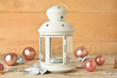 Ahşap zemin üzerinde yanan mum ve dekorla güzel bir Noel feneri.