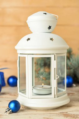 Ahşap zemin üzerinde yanan mum ve dekorla güzel bir Noel feneri.