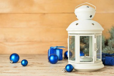 Ahşap zemin üzerinde yanan mum ve dekorla güzel bir Noel feneri.