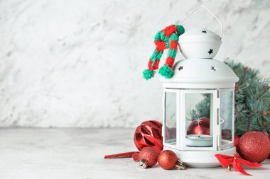 Güzel bir Noel feneri, yanan bir mum ve ışık arka planında toplar.