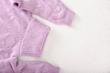 Hafif arka planda örülmüş yuvarlak yaka süveter