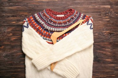 Askı ve kalın süveter ahşap arka planda