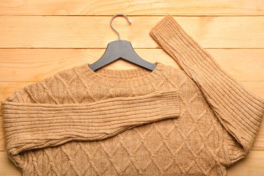 Ahşap arka planda örülü süveter askısı