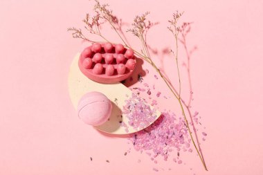 Banyo bombası, masaj sabunu, deniz tuzu ve arkaplanda kurumuş çiçek karışımı.