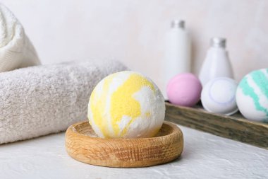 Banyo bombası ve arka planda havlular olan ahşap kase.