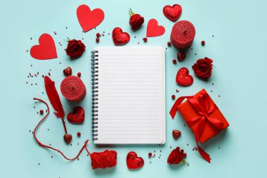 Boş defter ve renk arkaplanı üzerine hediye içeren romantik kompozisyon