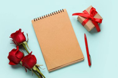 Hediyeli boş defter ve arkaplanda gül çiçekleri