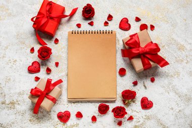 Boş defterli romantik kompozisyon ve grunge arkaplanda hediyeler