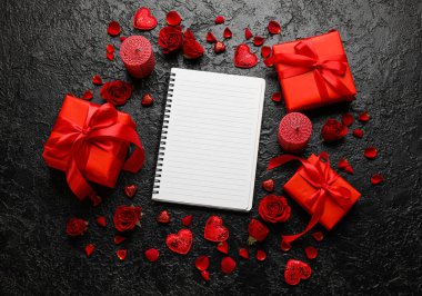 Boş defterli romantik kompozisyon ve koyu arkaplanda hediyeler