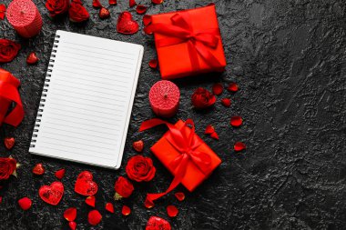 Boş defterli romantik kompozisyon ve koyu arkaplanda hediyeler