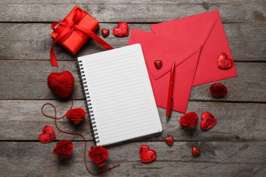 Ahşap arka planda boş defter, hediye ve zarflarla romantik kompozisyon
