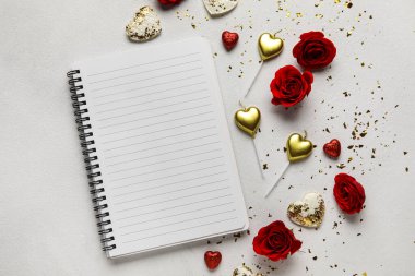 Açık arkaplanda boş defter olan romantik kompozisyon