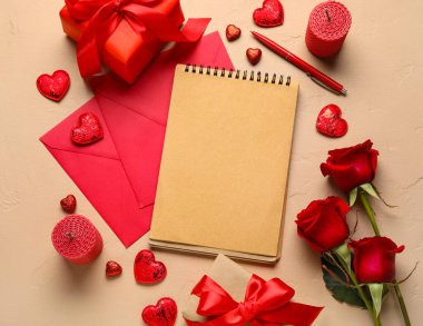 Boş defterli romantik kompozisyon, renk arkaplan üzerinde hediyeler ve zarflar