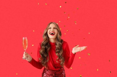 Şampanyalı ve renkli konfetileri olan güzel genç bir kadın.