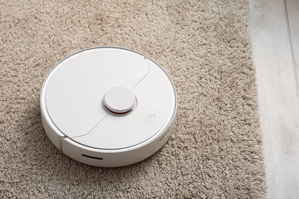 Modern robot süpürgesi yumuşak halıda.