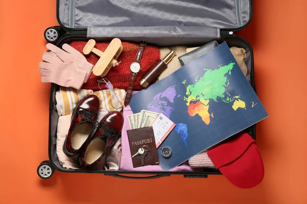 Koffer Mit Gepackten Reiseutensilien Und Weltkarte Auf Farbigem Hintergrund — Stockfoto