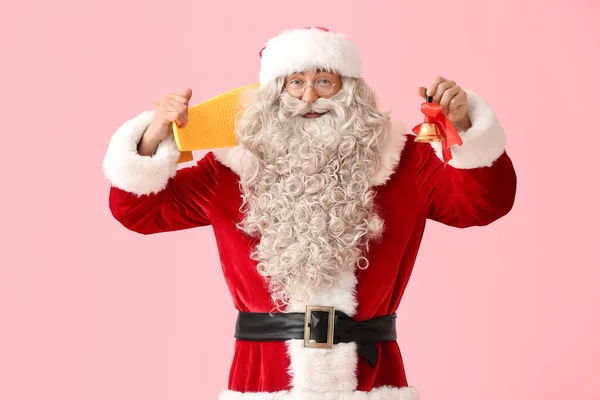 Weihnachtsmann Mit Weihnachtsglocke Und Skateboard Auf Rosa Hintergrund — Stockfoto