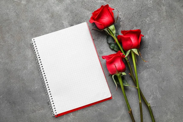 Grunge arka planında gül çiçekleri olan boş bir defter